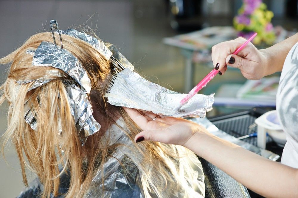 A Woman is Getting Her Hair Dyed in a Salon — Fraser Shores Hair Design In Urraween, QLD