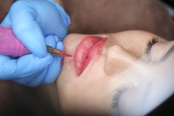 Una donna si sta facendo un tatuaggio permanente sulle labbra.