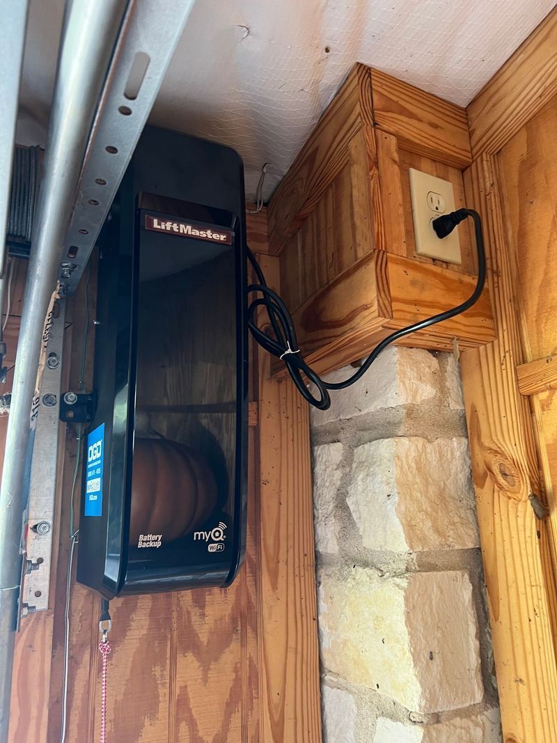 A garage door opener is attached to a wooden wall.