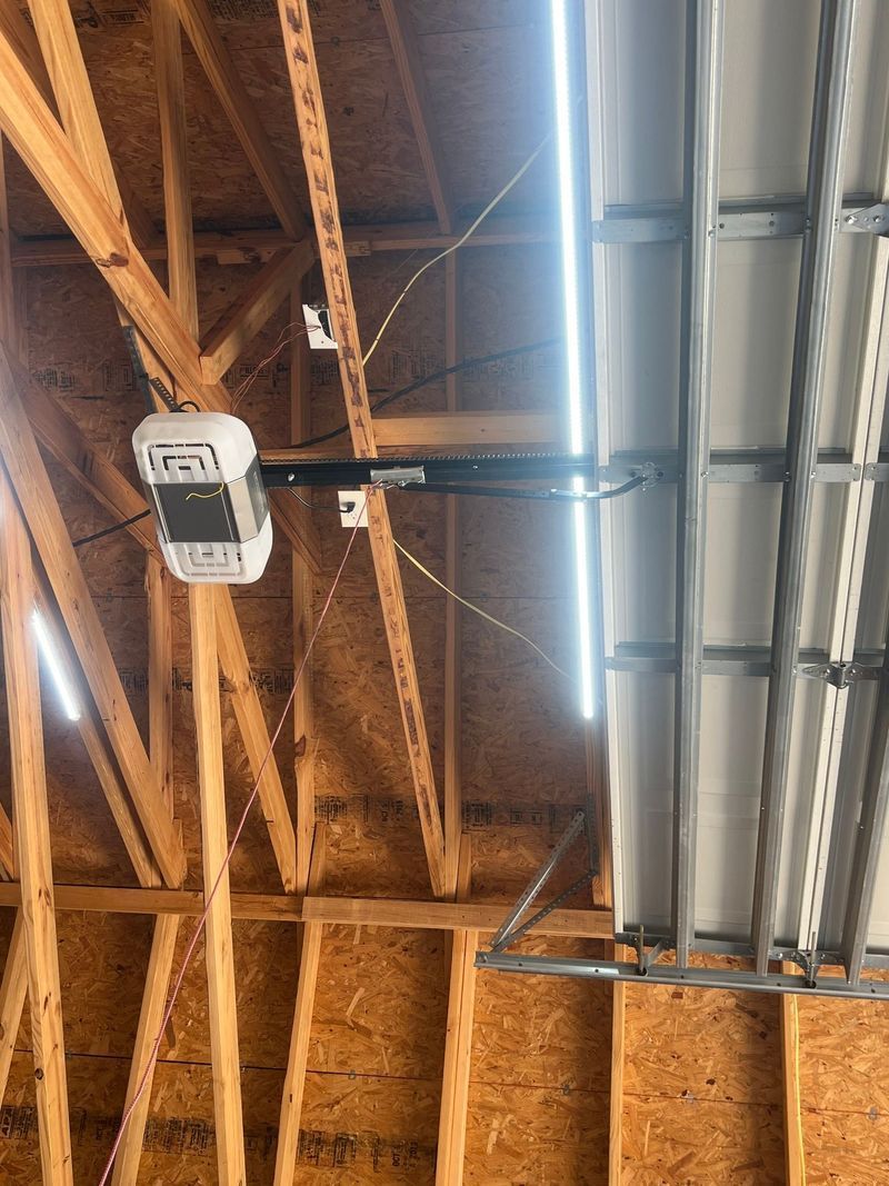 A garage door opener is hanging from the ceiling of a building.