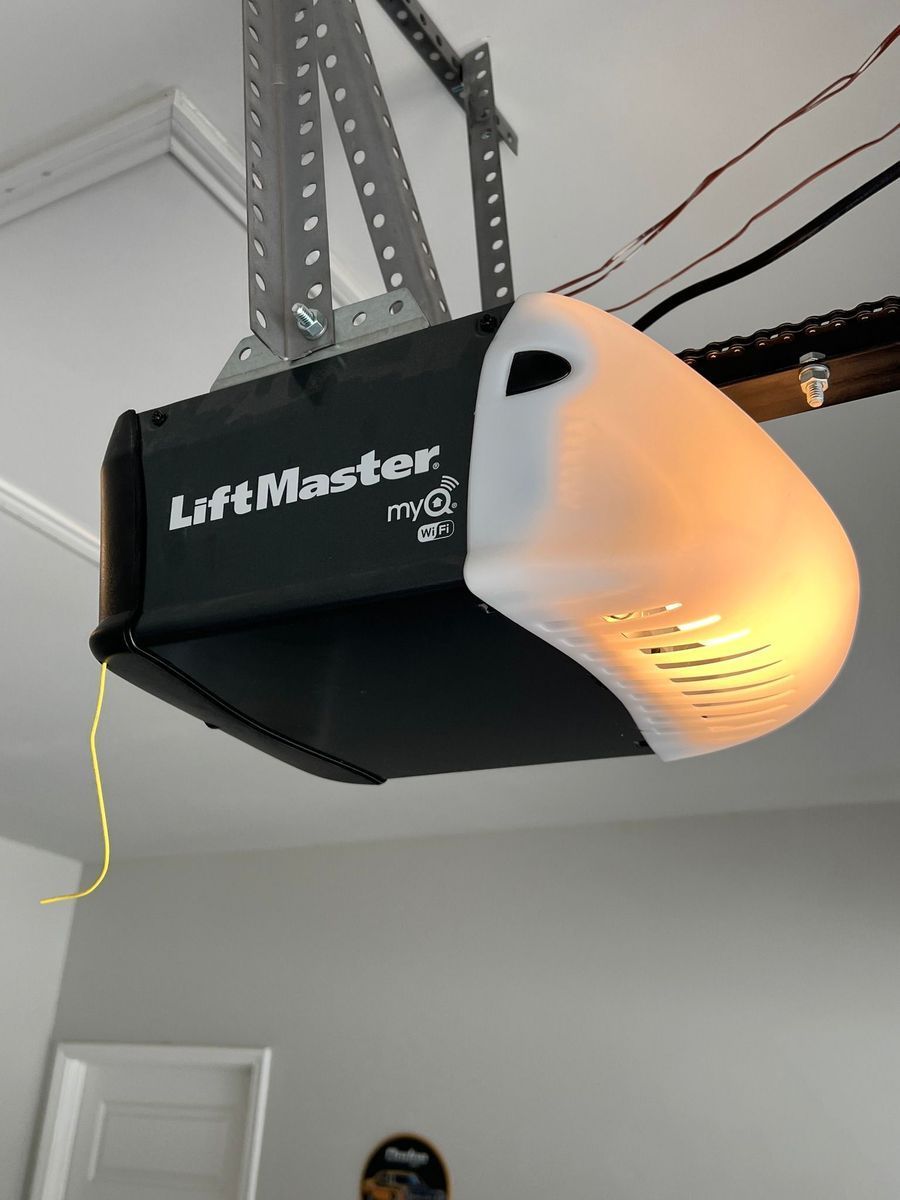 A liftmaster garage door opener is hanging from the ceiling