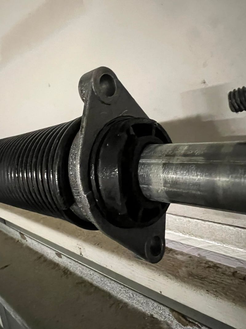 A close up of a garage door spring on a garage door.