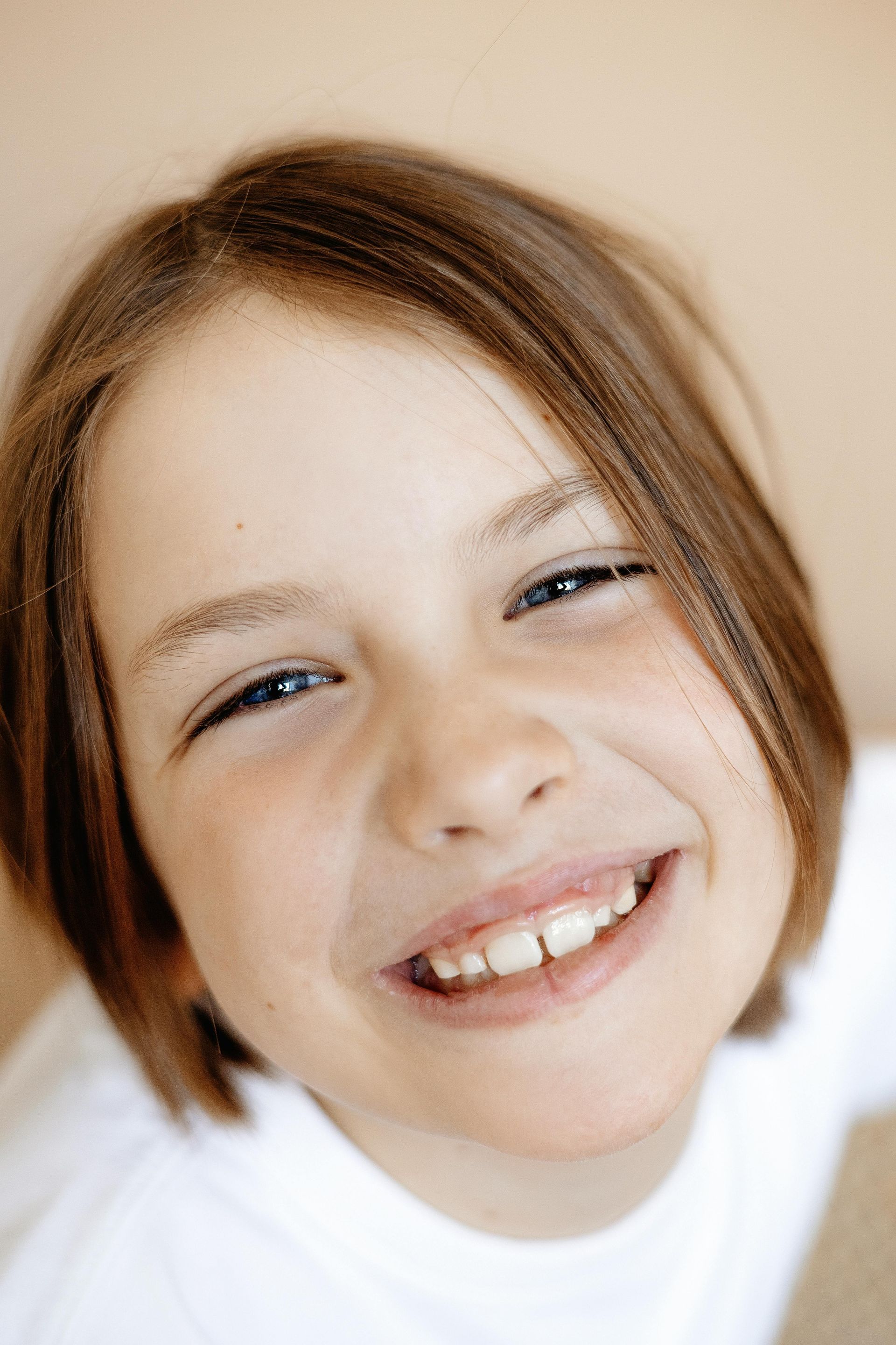 A young girl with brown hair is smiling for the camera.