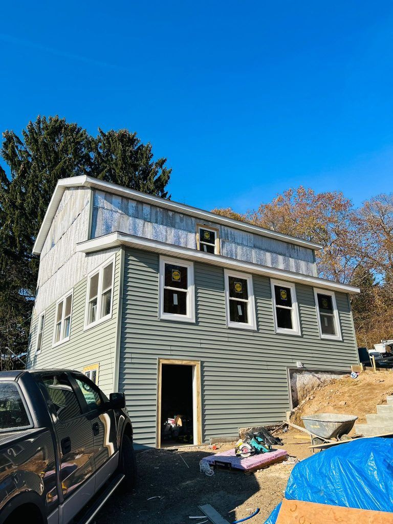 A truck is parked in front of a house under construction.