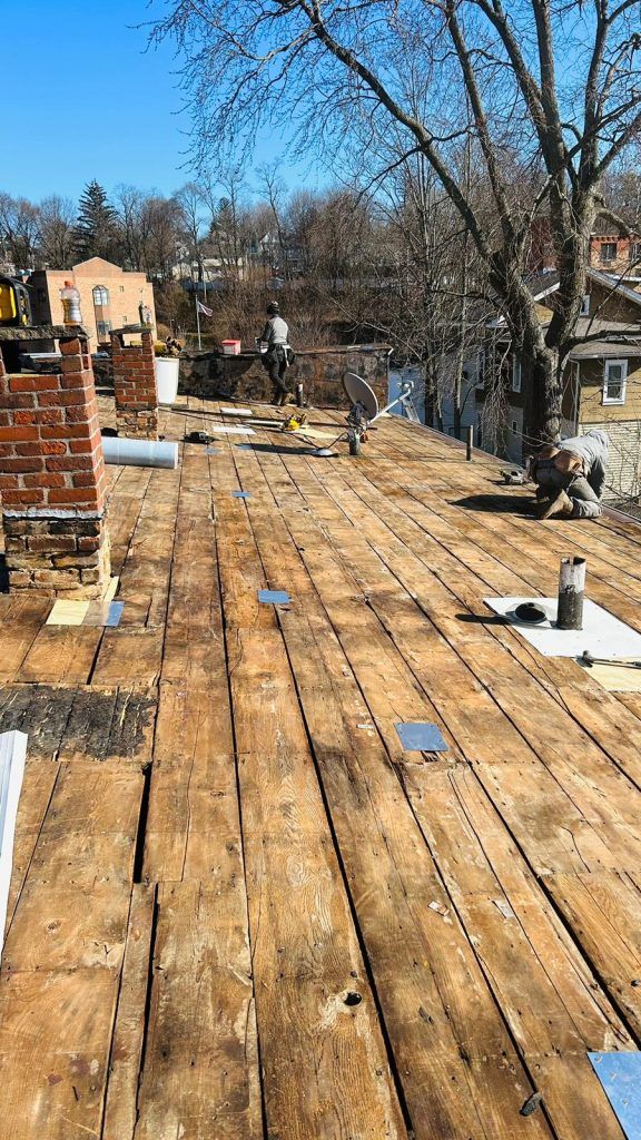 A wooden deck is being built on the roof of a house.