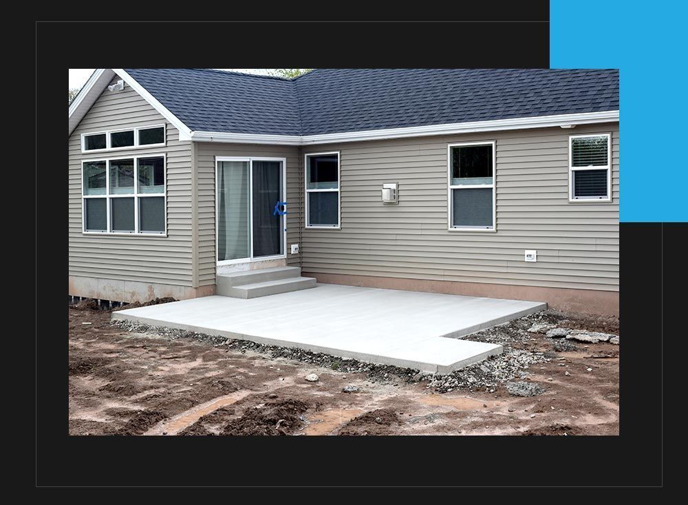 A house with a concrete patio in front of it.