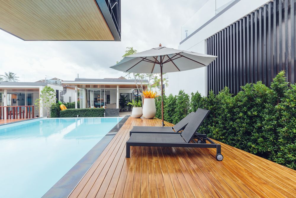 Poolside scene with lounge chairs, umbrella, and a light-coloured wooden deck — Nielsen Construction in Wagga Wagga, NSW