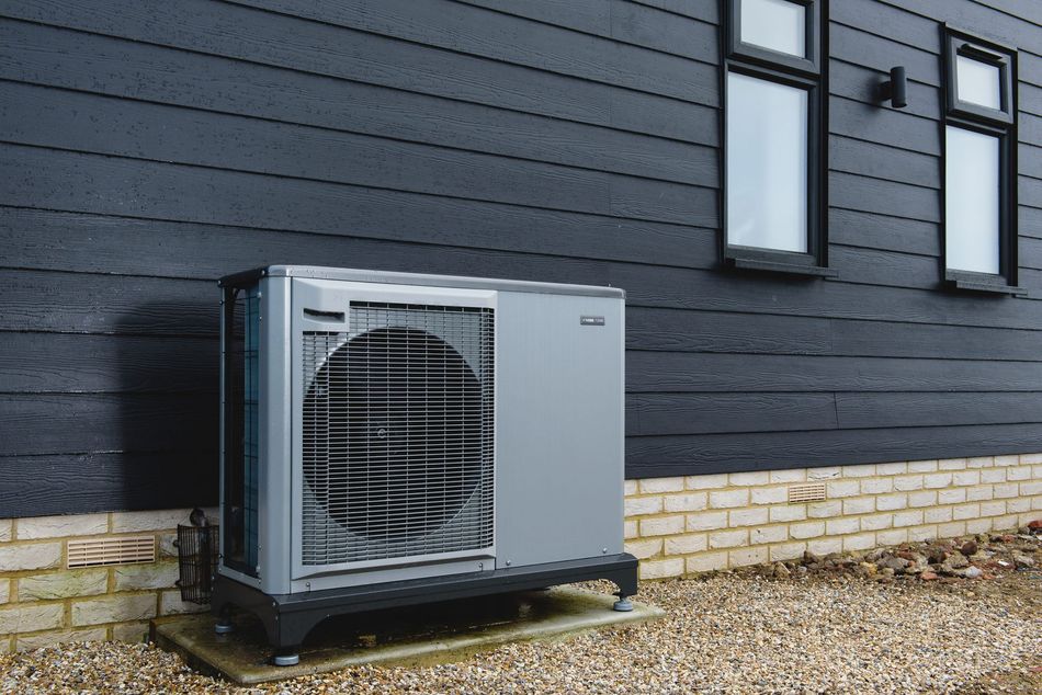 A large air conditioner is sitting on the side of a building.
