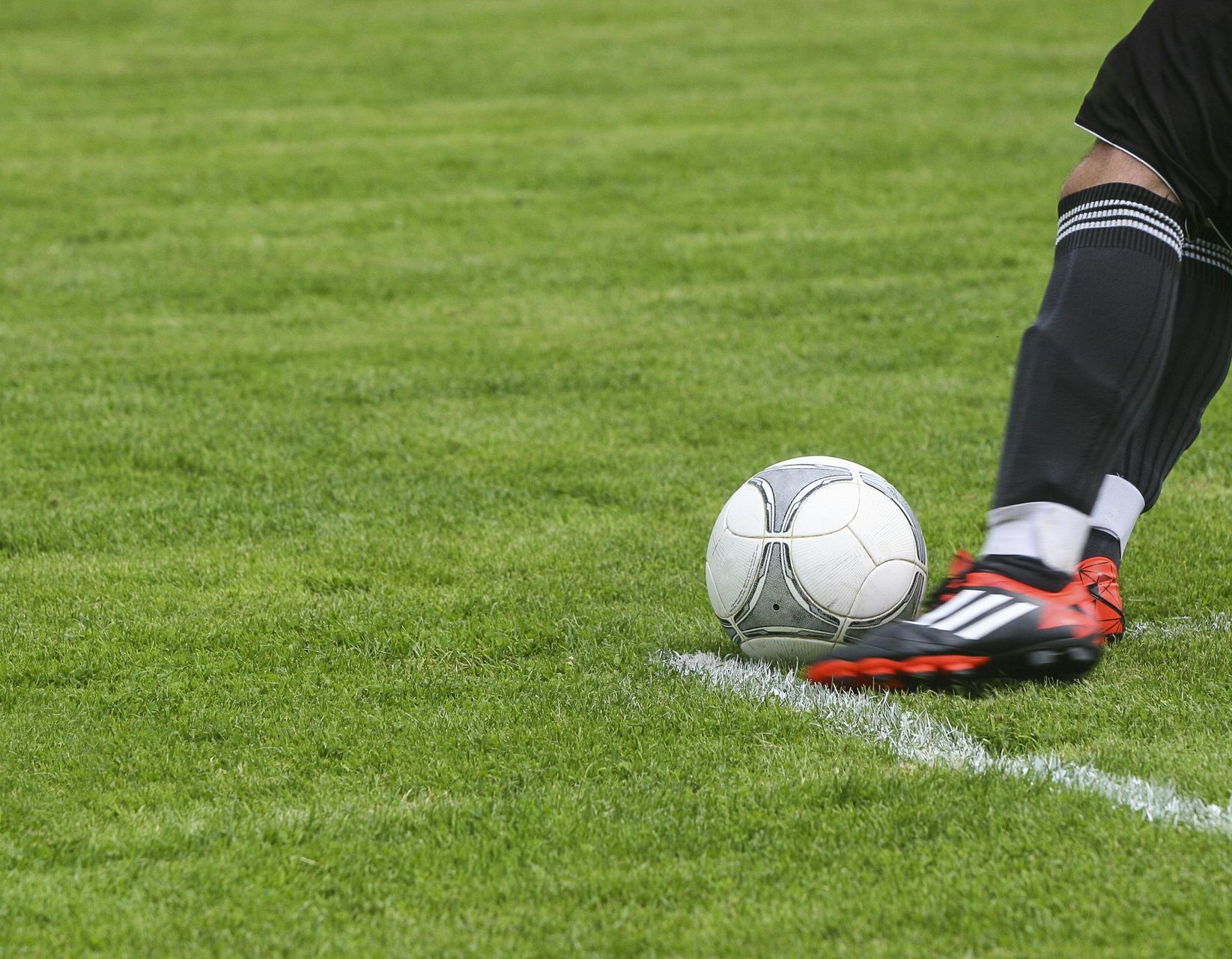 Eine Person kickt einen Fußball auf einem Feld