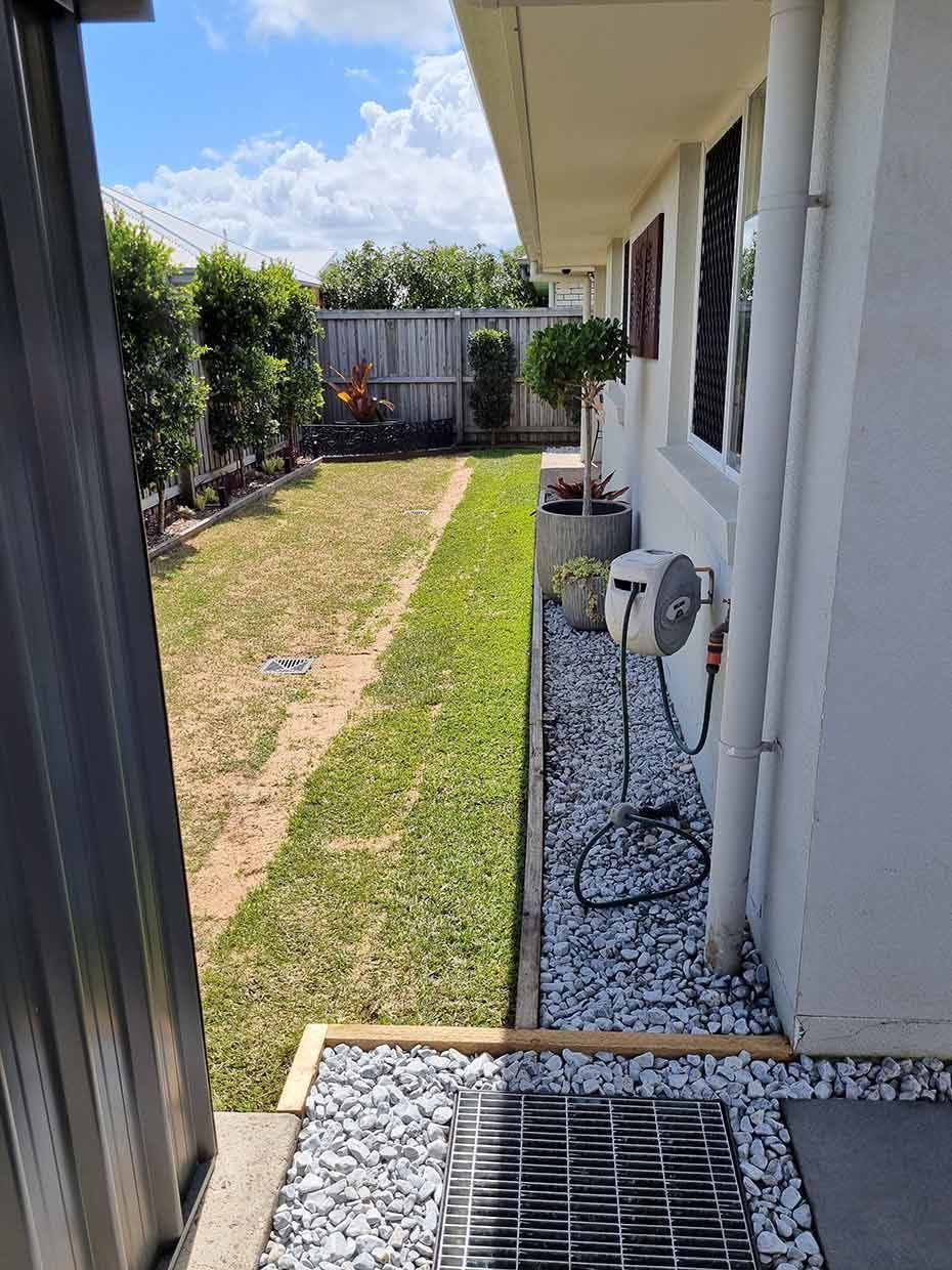 A White House With a Lush Green Lawn and a Fan on the Side of It — All Aspects Landscaping In Peregian Beach, QLD