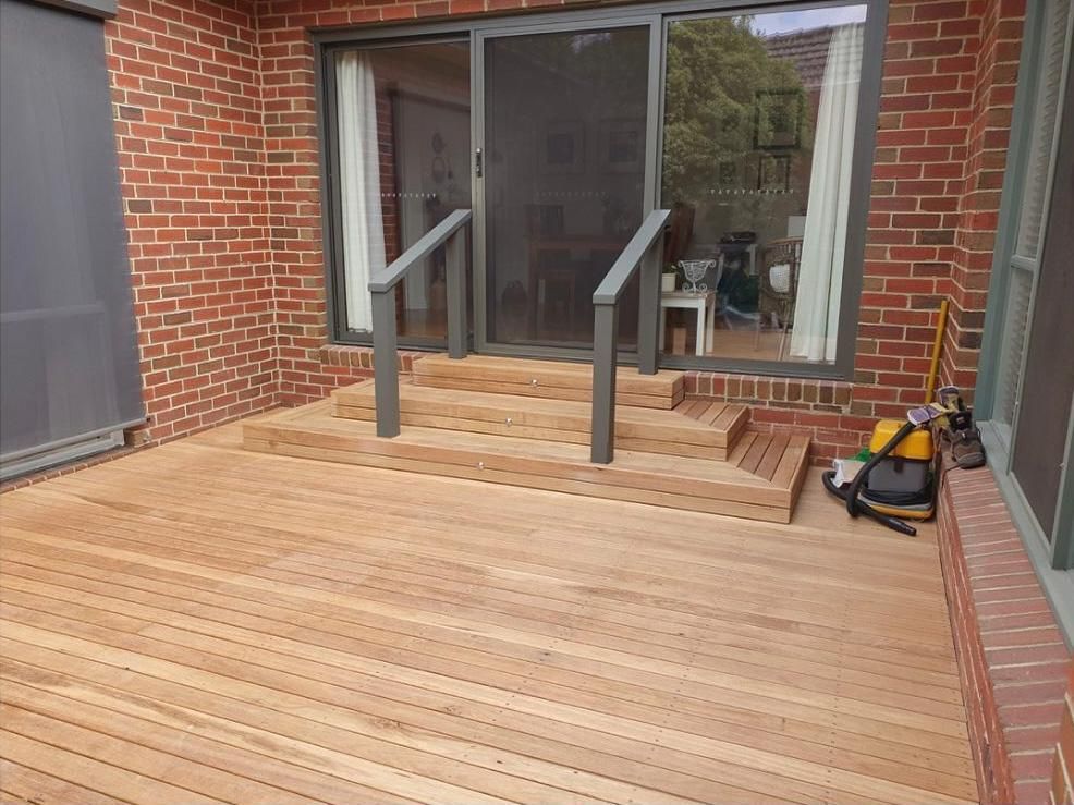 A Wooden Deck With Stairs Leading Up To A Brick Building — All Aspects Landscaping In Peregian Beach, QLD