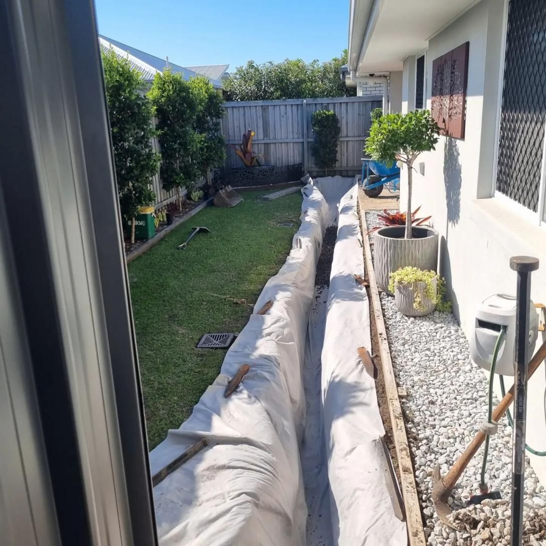 A Drainage System Is Being Installed In The Backyard Of A House — All Aspects Landscaping In Peregian Beach, QLD