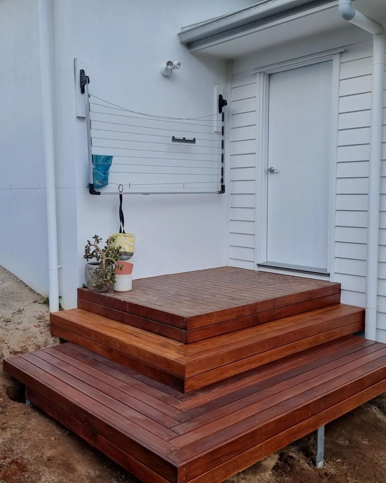 A Wooden Deck With Stairs Leading Up To A White House — All Aspects Landscaping In Peregian Beach, QLD