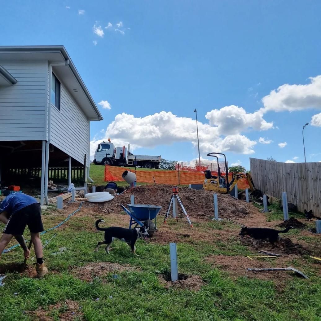 A Man And A Dog Are Working In A Yard In Front Of A House — All Aspects Landscaping In Peregian Beach, QLD