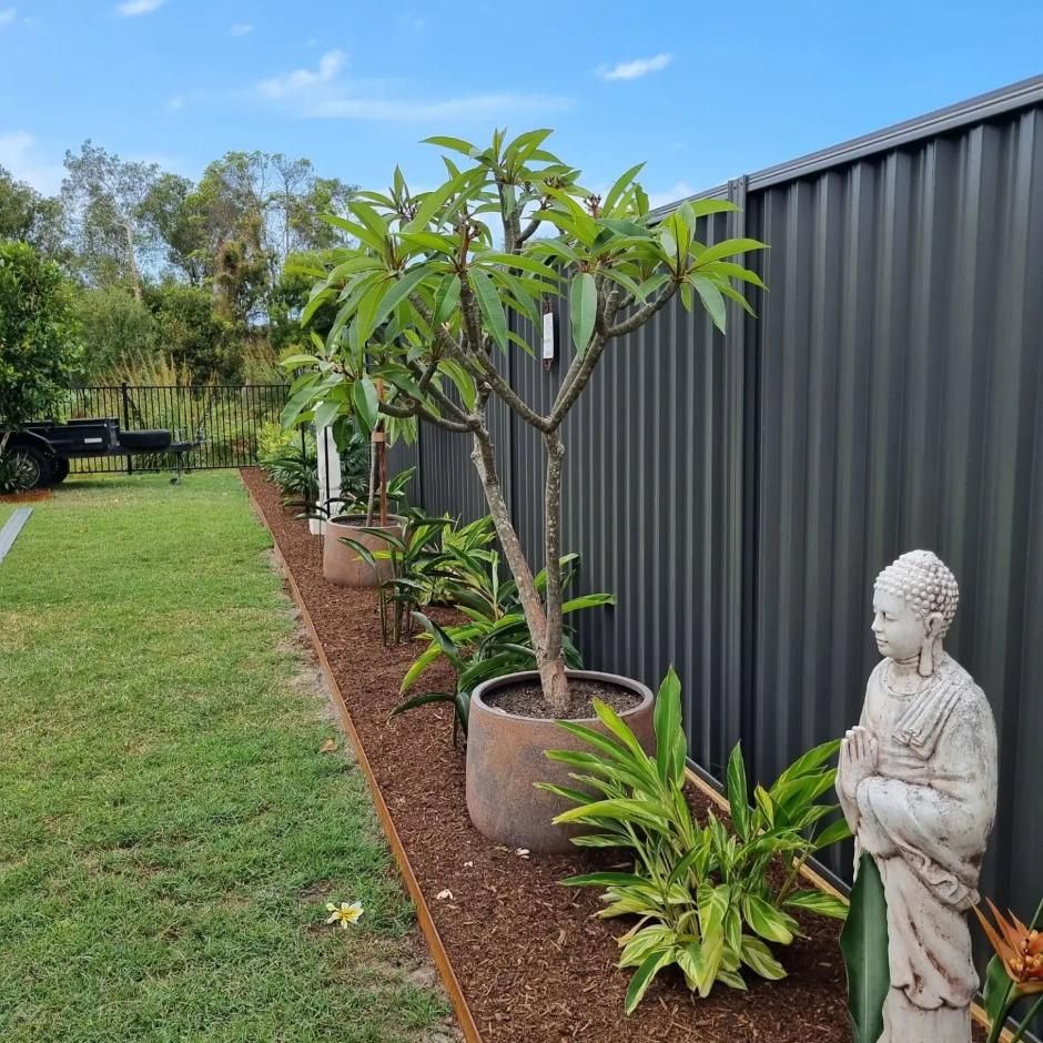 Garden With Potted Plants, A Buddha Statue And A Metal Fence — All Aspects Landscaping In Cooroy, QLD