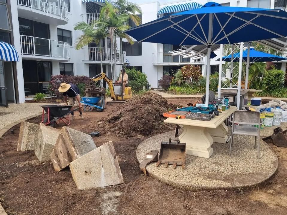 A Group Of People Are Working In A Garden In Front Of A Building — All Aspects Landscaping In Cooroy, QLD
