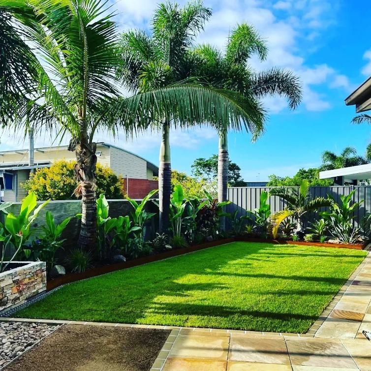 A Lush Green Lawn With Palm Trees In The Background — All Aspects Landscaping In Buderim, QLD