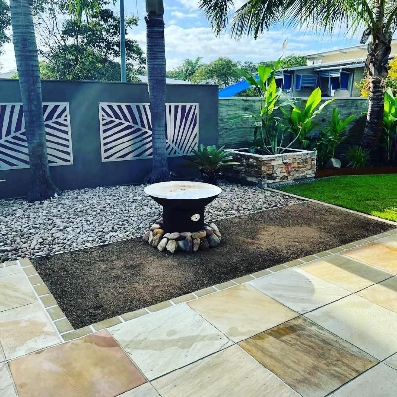 A Patio With A Table And A Fire Pit In The Middle Of It — All Aspects Landscaping In Coolum Beach, QLD