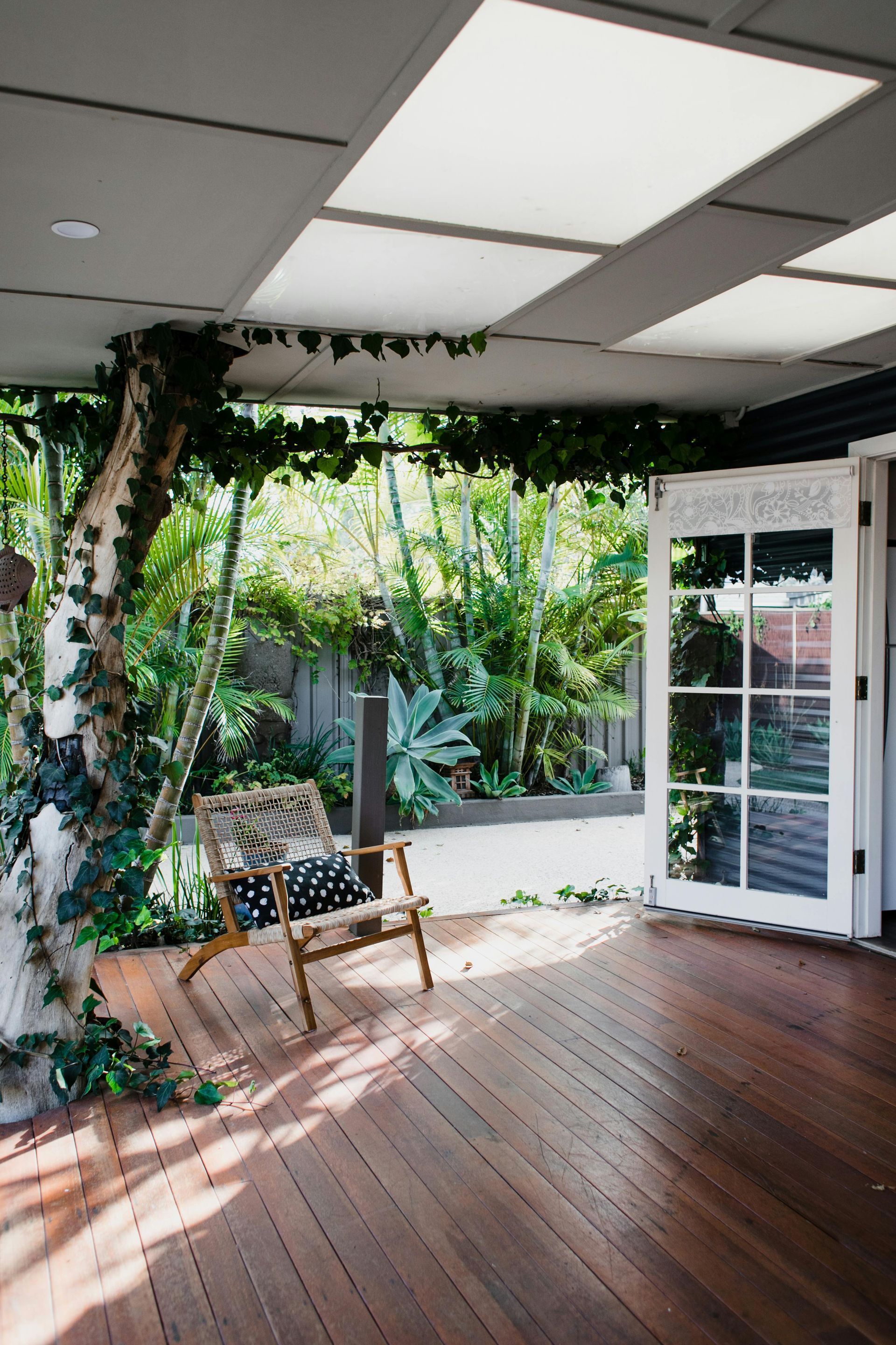 White house with a veranda, stairs, and a landscaped front yard on a sunny day. — All Aspects Landscaping In Peregian Beach, QLD