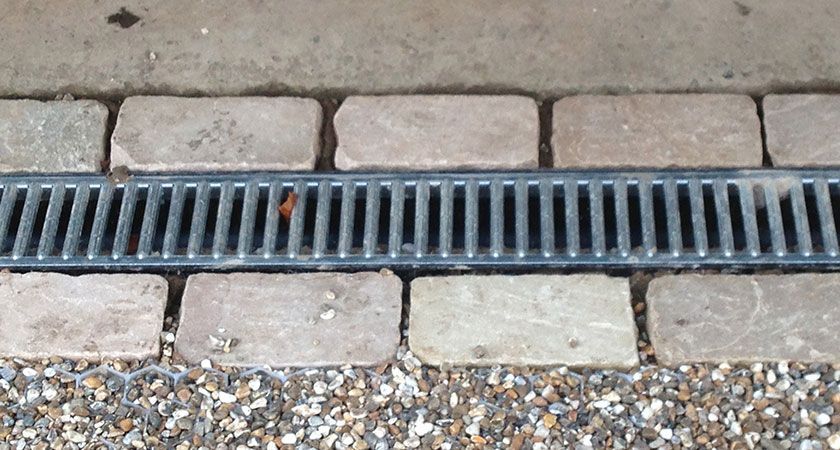 A Drain on a Sidewalk With Bricks and Gravel — All Aspects Landscaping In Peregian Beach, QLD