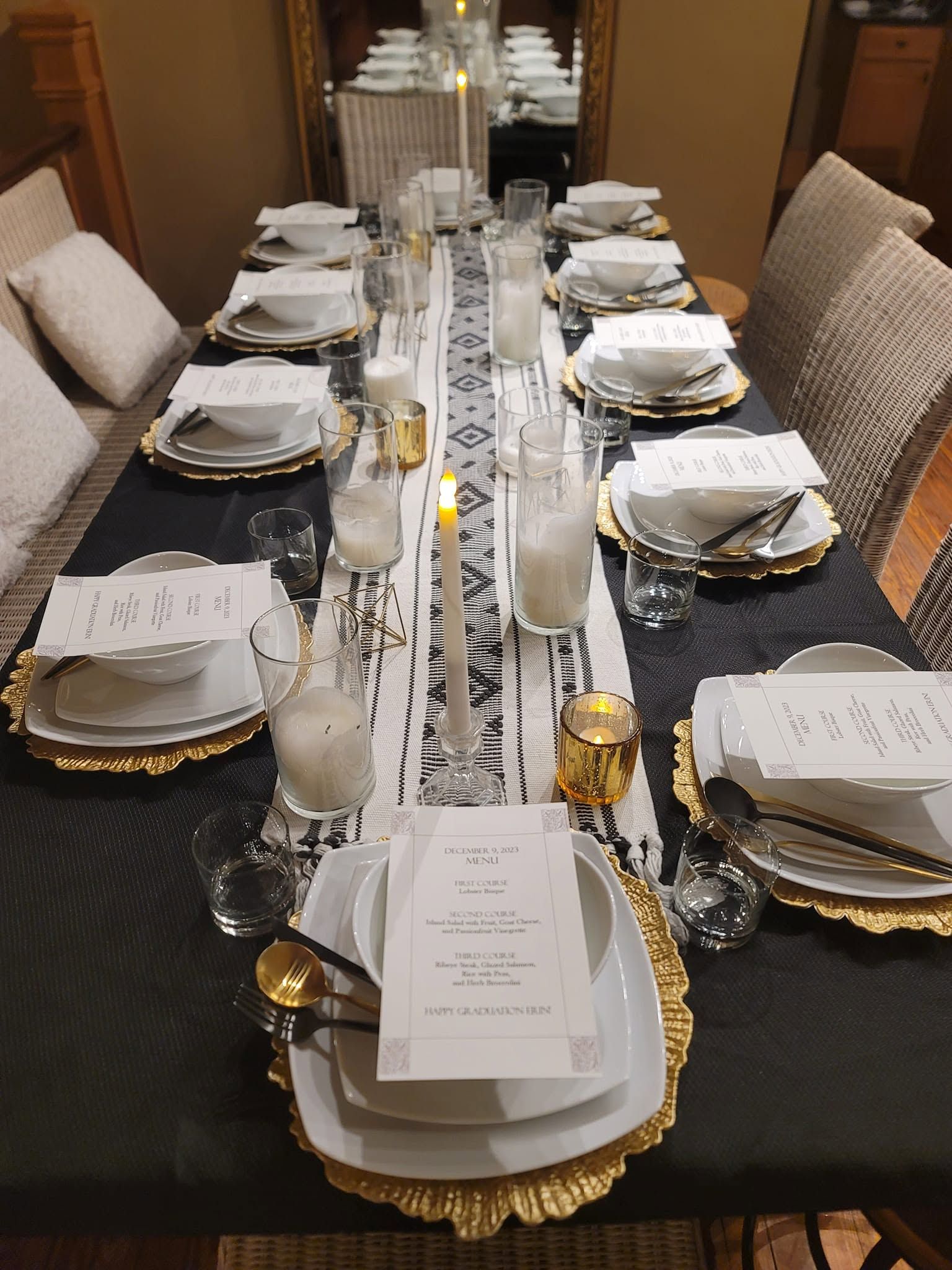 Elegant dining table set with gold-rimmed plates, white napkins, and glassware