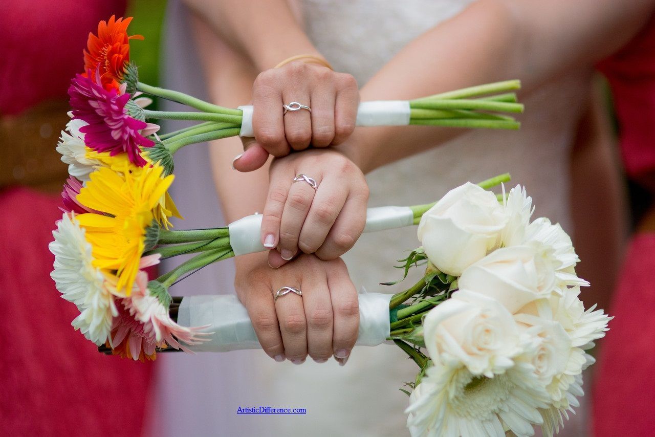 three hands holding flowers