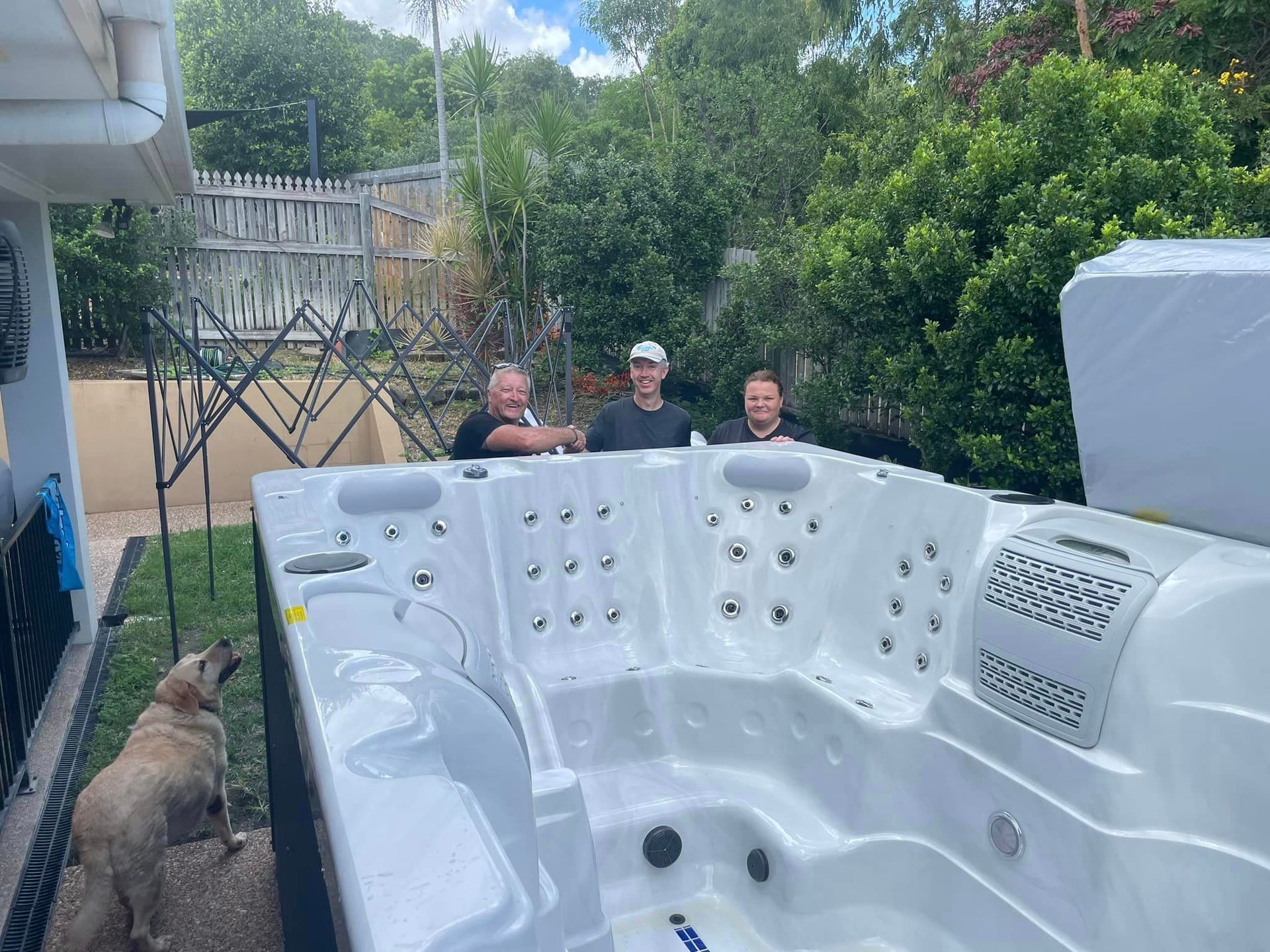 Group Of People Are Standing Around A Large White Hot Tub — ECHO Spas in Garbutt, QLD