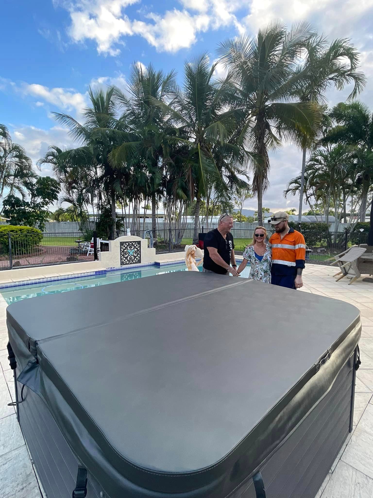 Group Of People Are Standing Around A Hot Tub — ECHO Spas in Garbutt, QLD