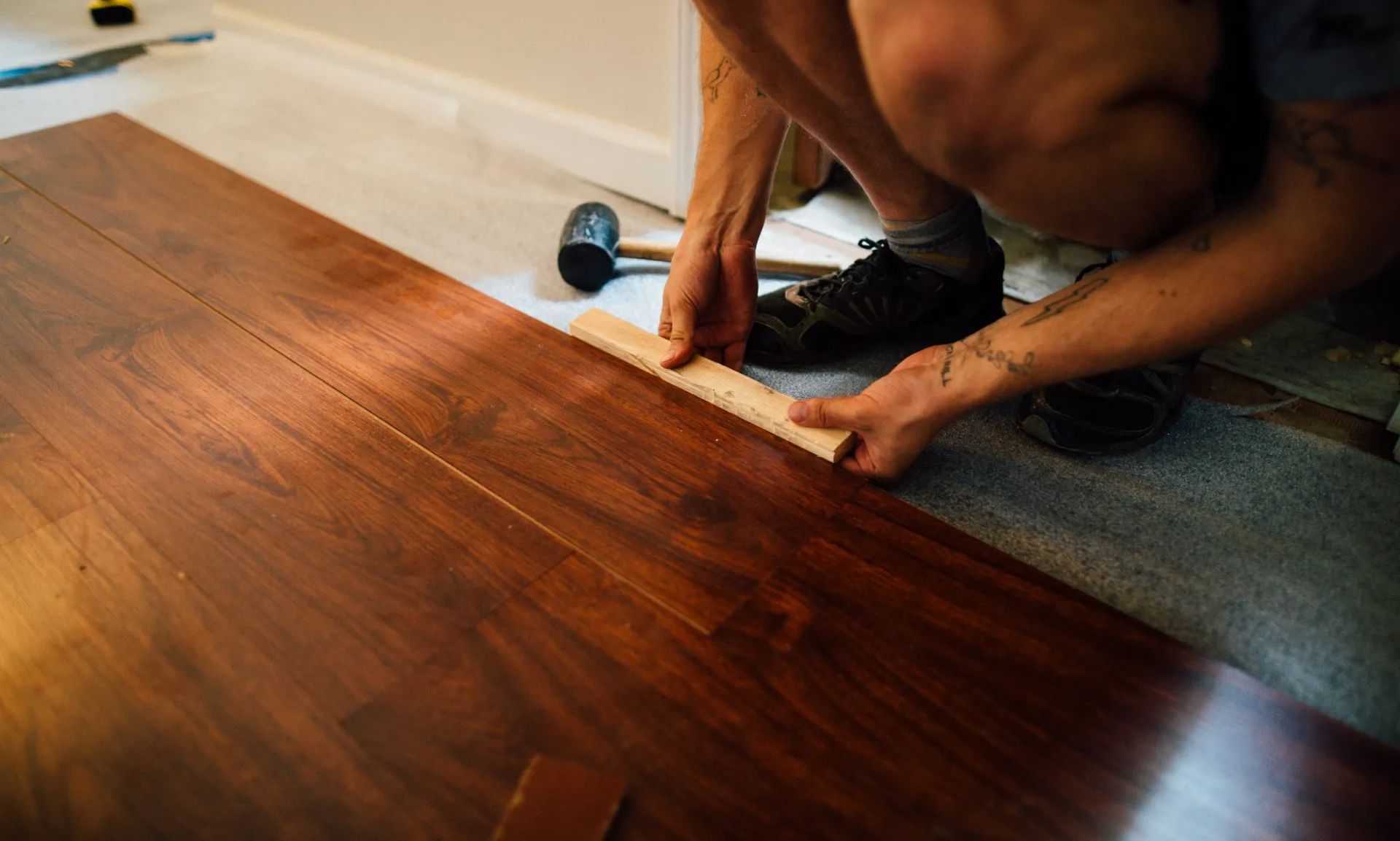 new hardwood flooring being installed in a room that previously had carpeting