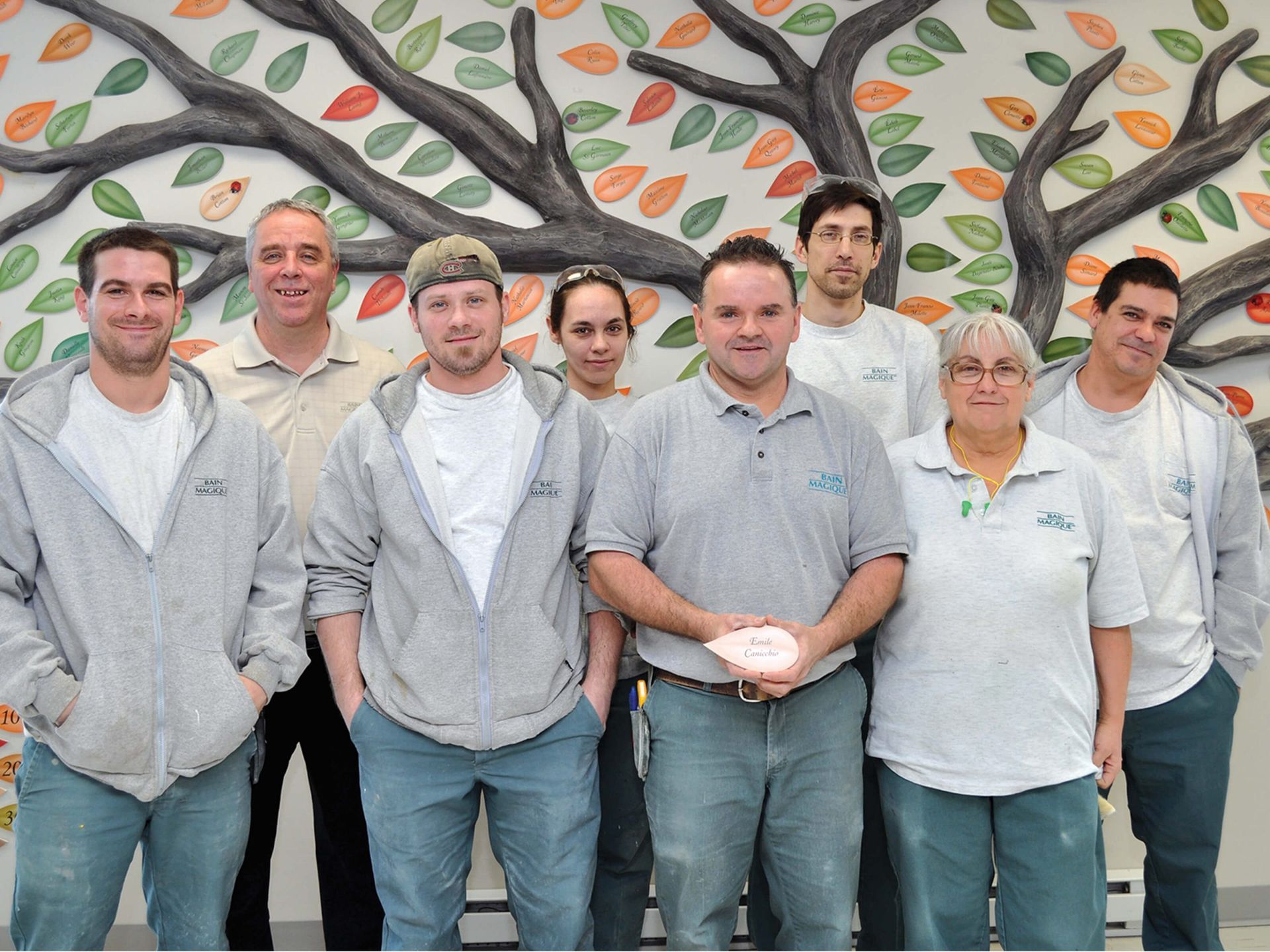 Employee Team Photo in Front of a Tree Mural