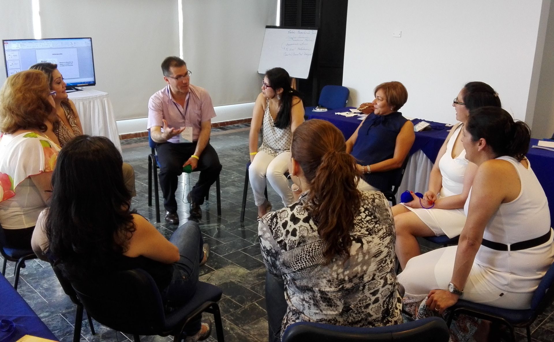 Grupo de personas sosteniendo un certificado, algunos sonriendo, frente a un fondo de estudio de radio.