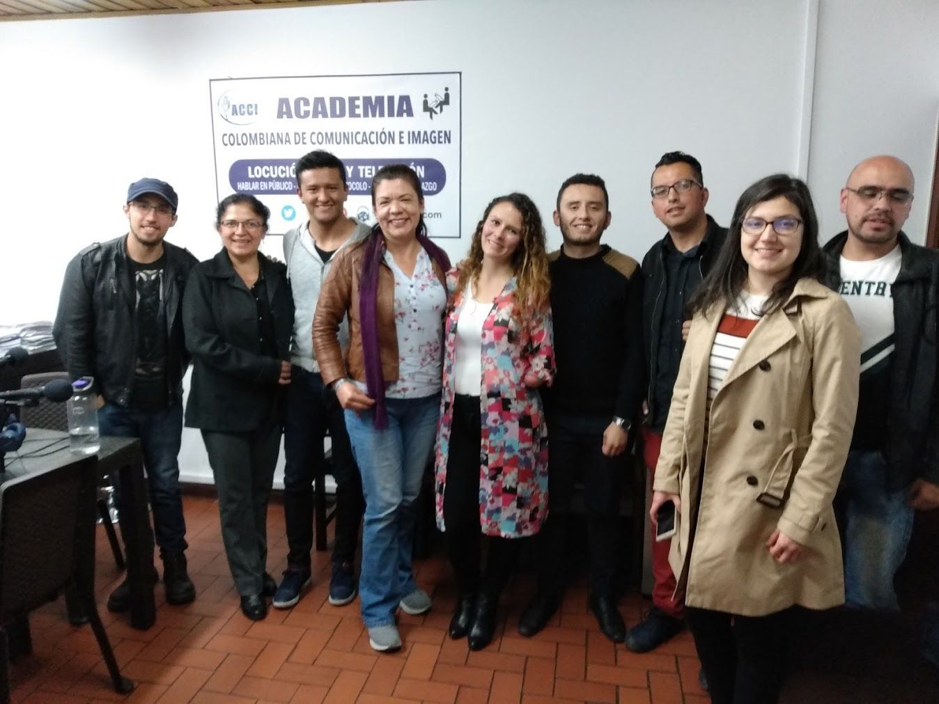 Grupo de personas sosteniendo certificados, sonriendo en una habitación bien iluminada.