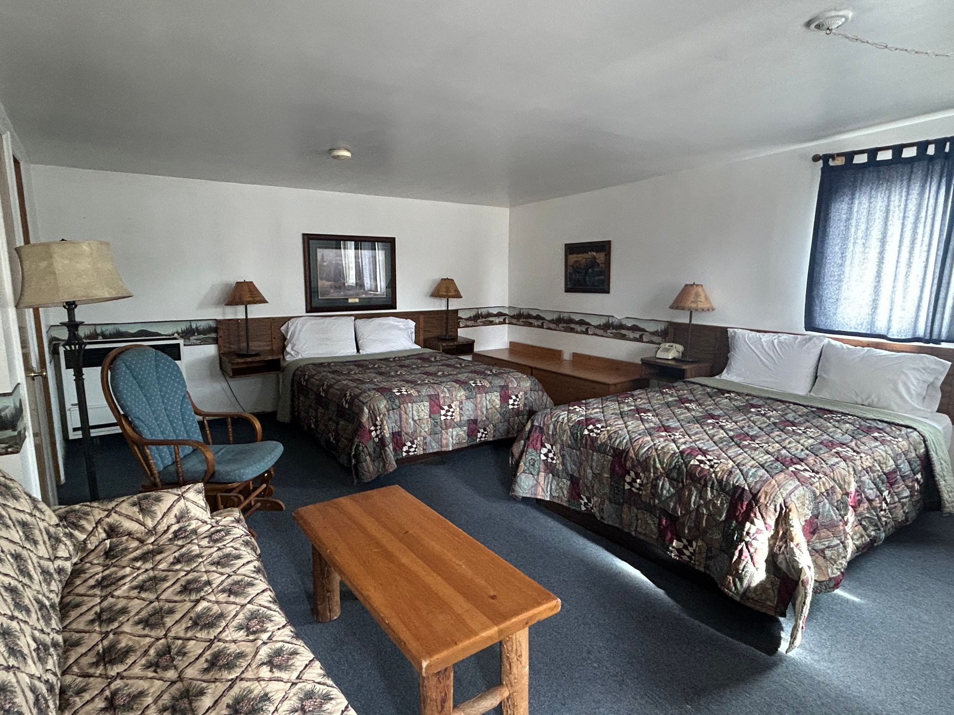 A hotel room with two beds , a couch , and a table.