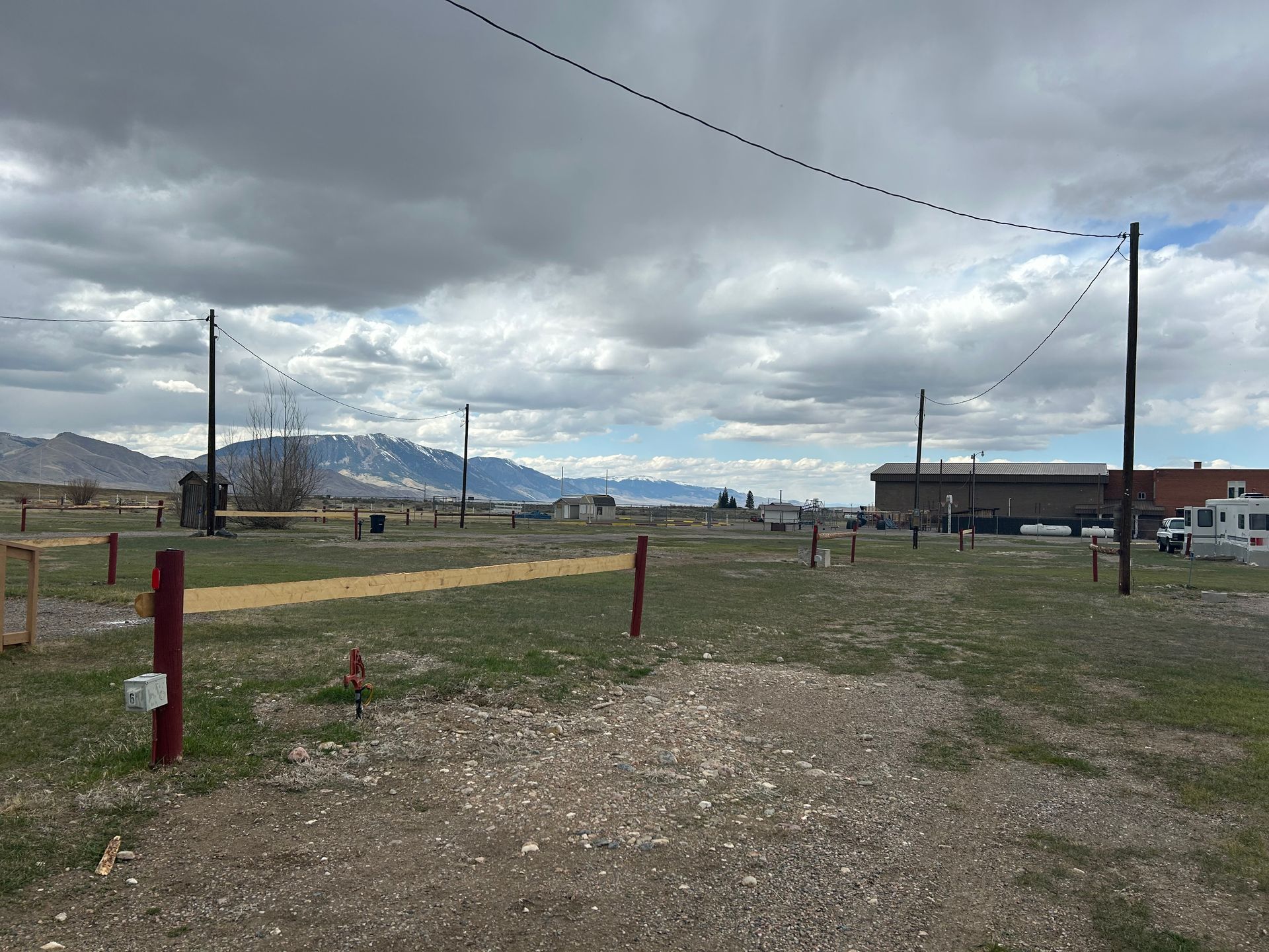 A dirt road with a red pole in the middle of it