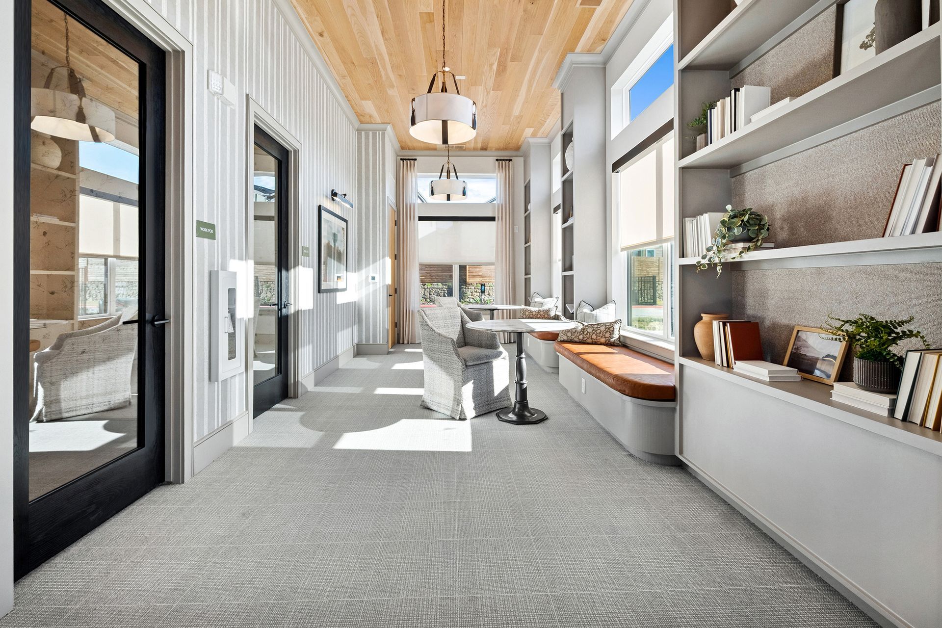A light-filled hallway with a built-in bench, bookshelf, and a table.