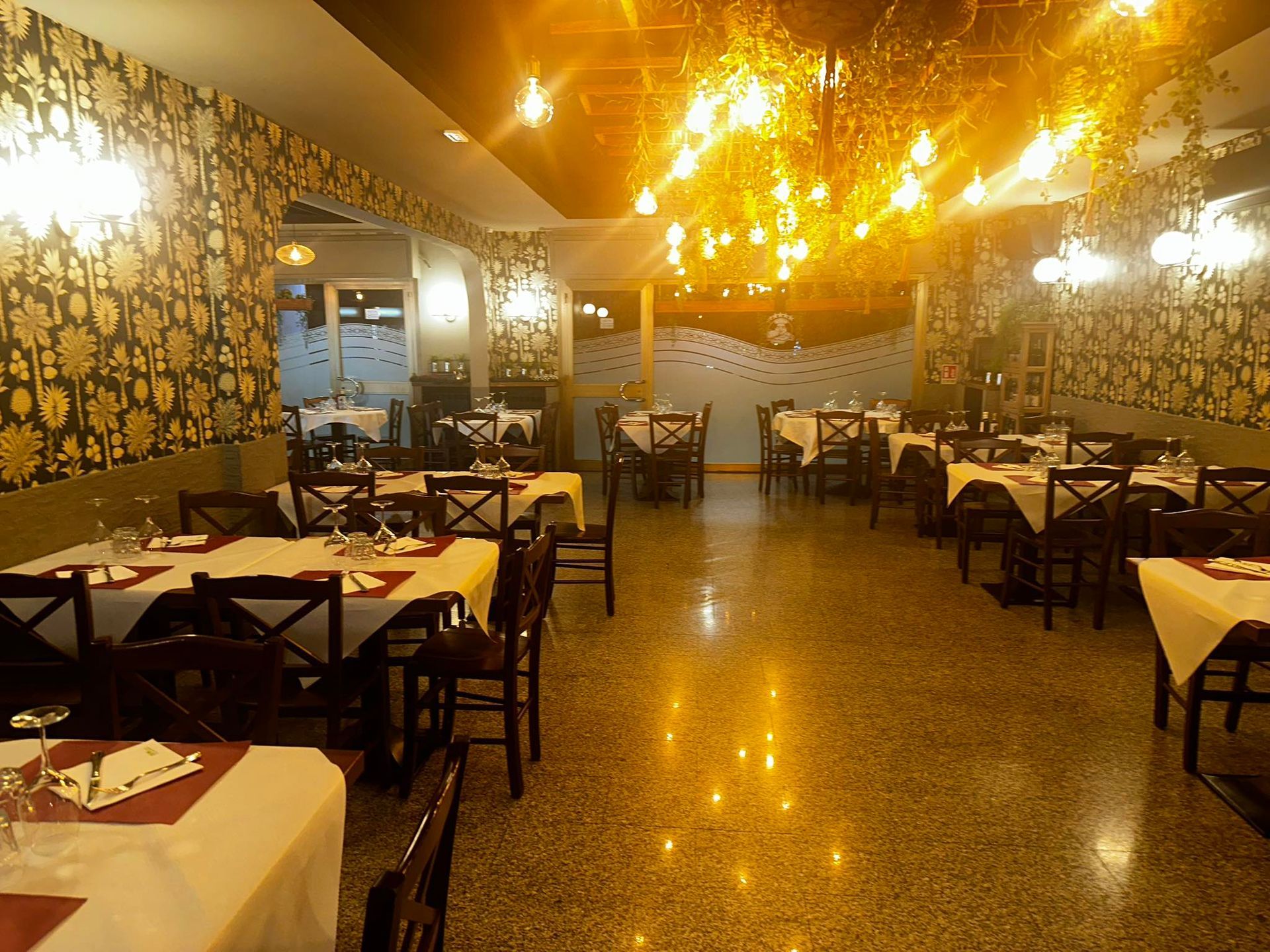 Una grande sala da pranzo con tavoli e sedie e un lampadario