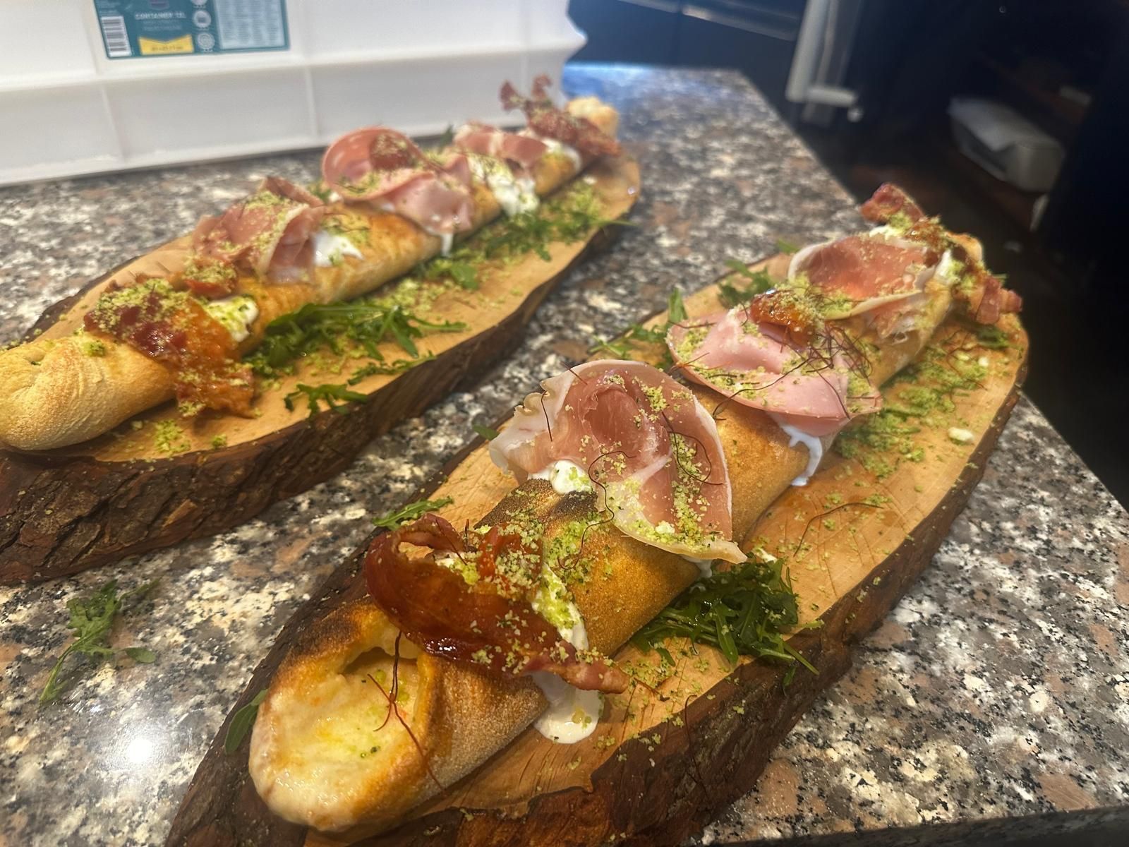 Un tagliere di legno pieno di carne e verdure su un tavolo.