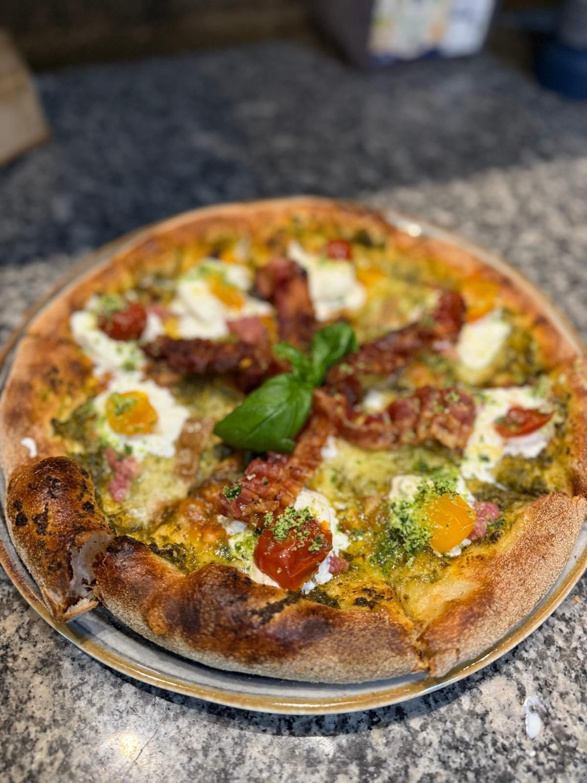 Una pizza con tanti condimenti è in una scatola.