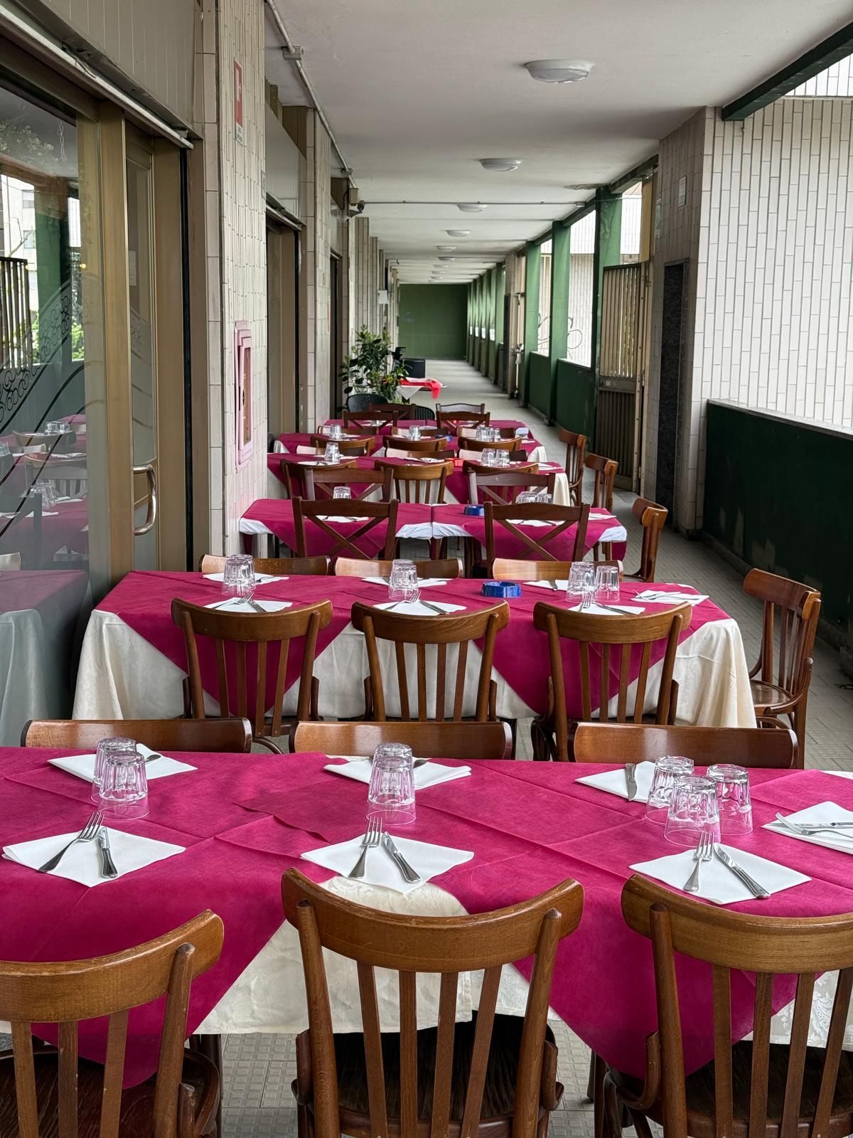 Un ristorante pieno di tavoli, sedie e un lampadario.