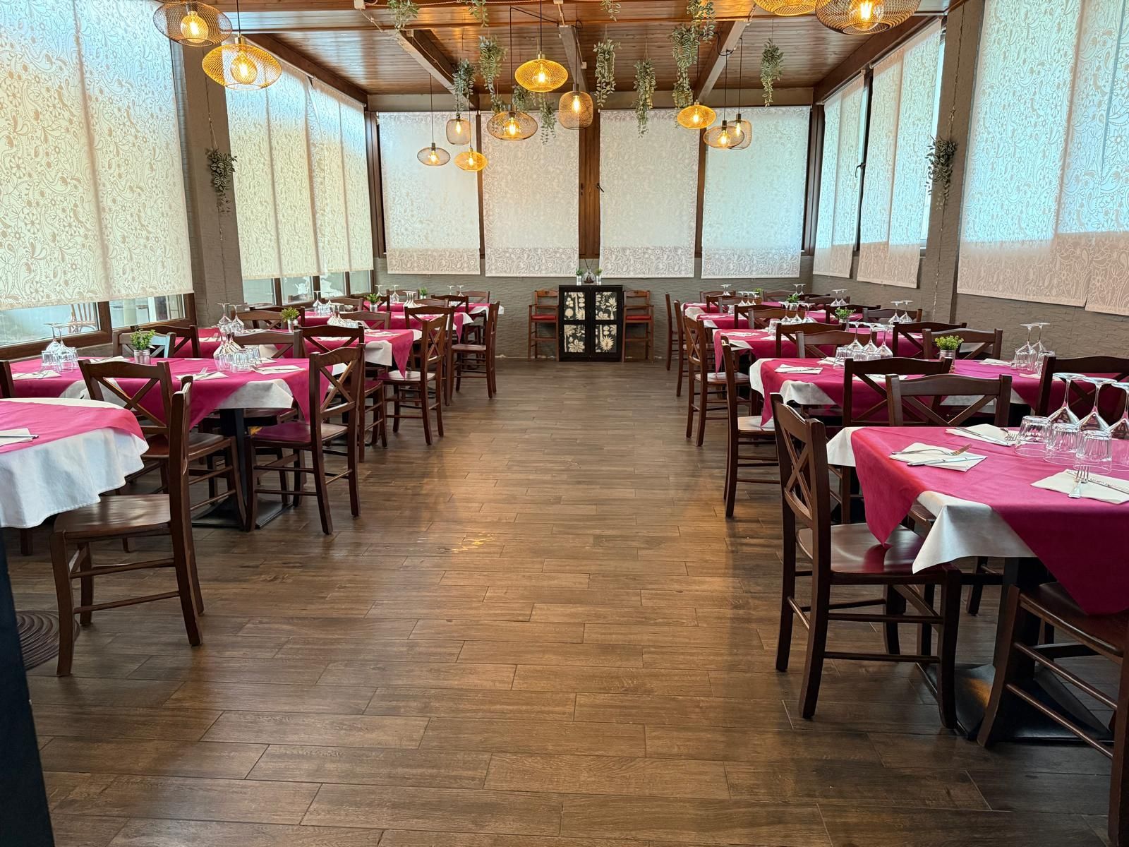 Un ristorante con tavoli e sedie apparecchiati per la cena