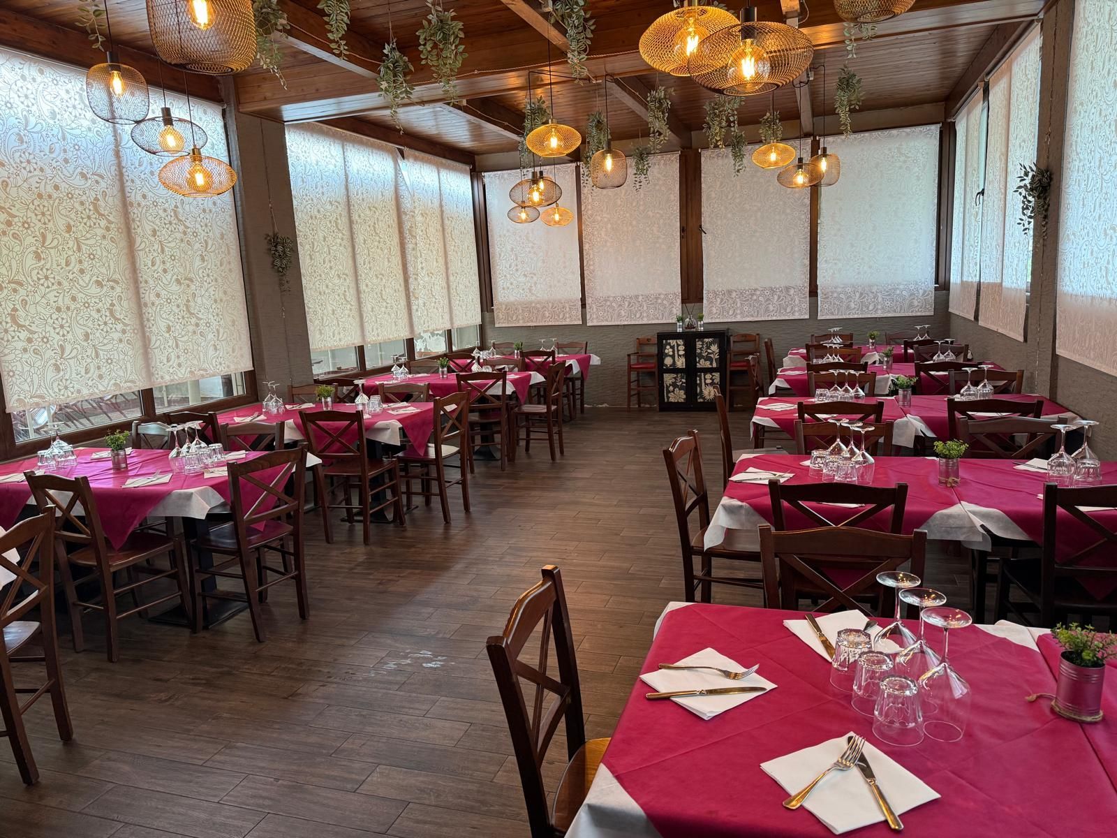 Una lunga sala da pranzo con tavoli e sedie