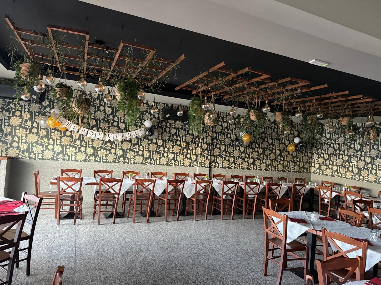 Una grande sala da pranzo con tavoli e sedie e un lampadario