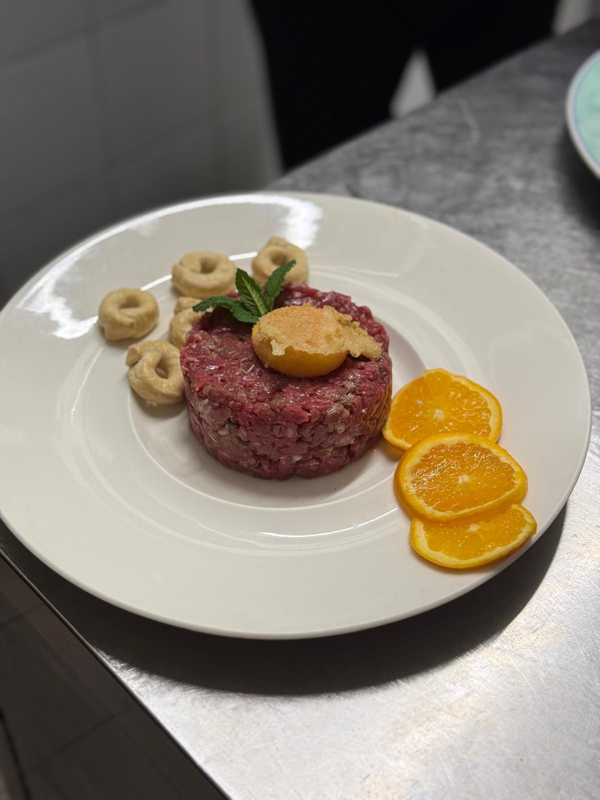 Una pizza con pancetta, formaggio e basilico su un piatto bianco.