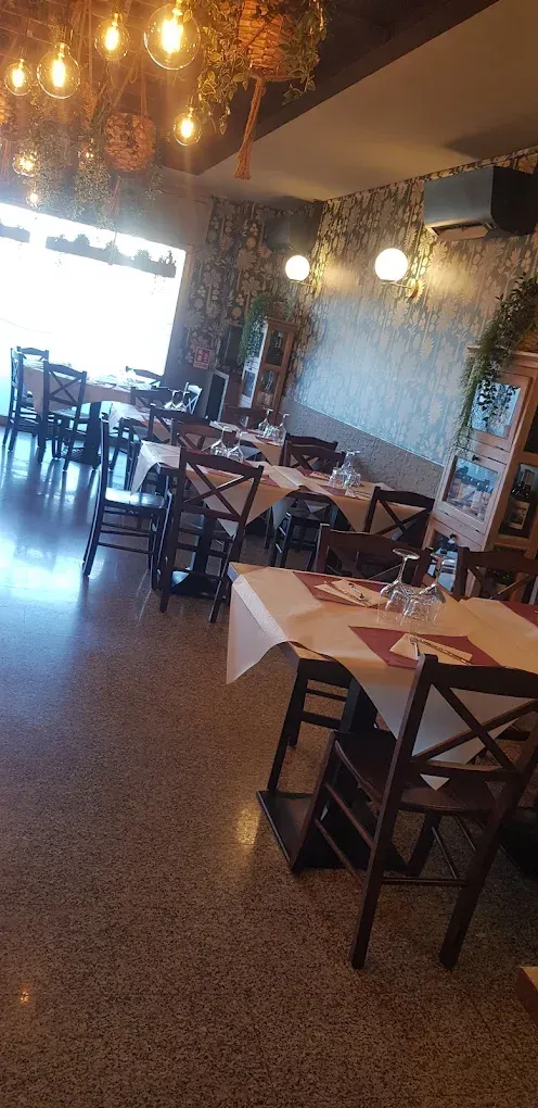 Un ristorante pieno di tavoli, sedie e un lampadario.