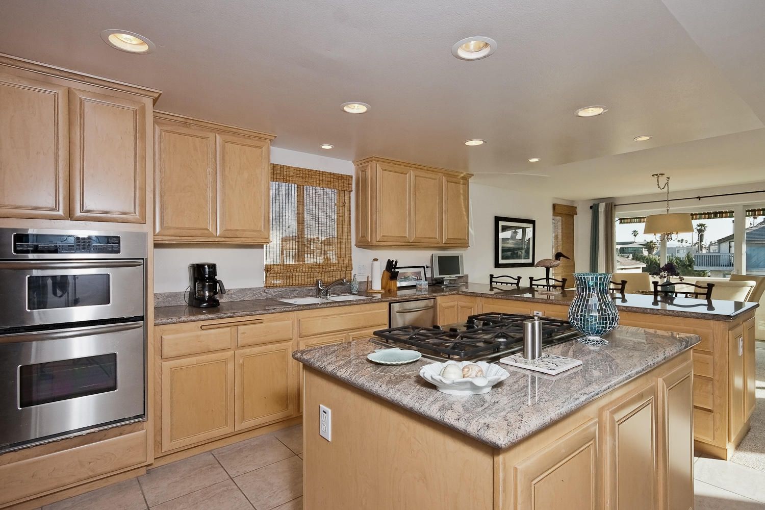 A kitchen with white cabinets and a gray island