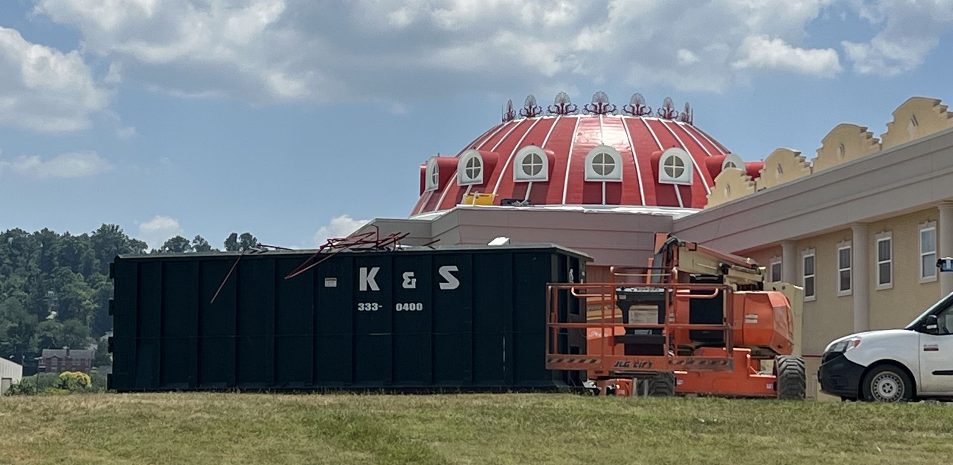 A large red dome is being built in front of a large black container that says k & s