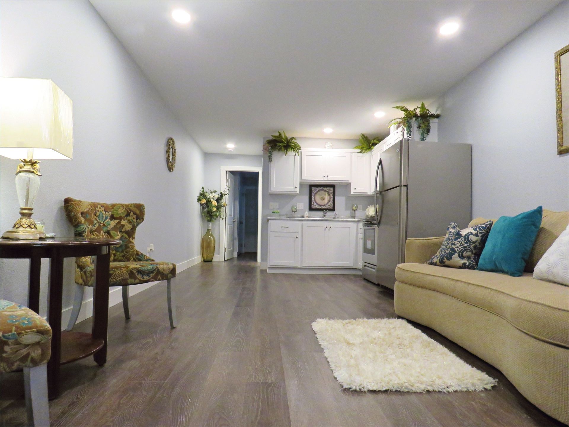 A living room with a couch , chair , table and rug.