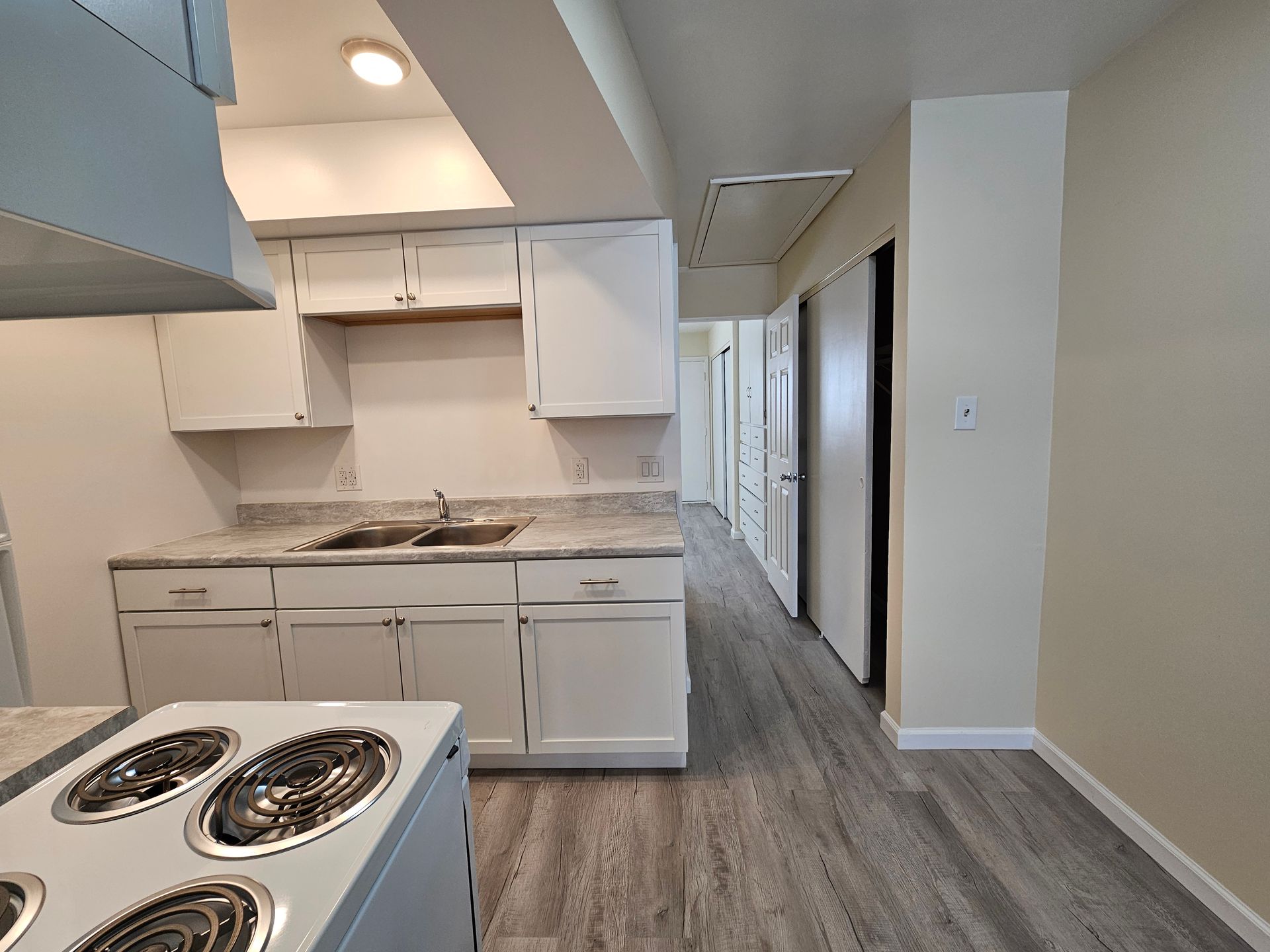 A kitchen with white cabinets and a stove top oven