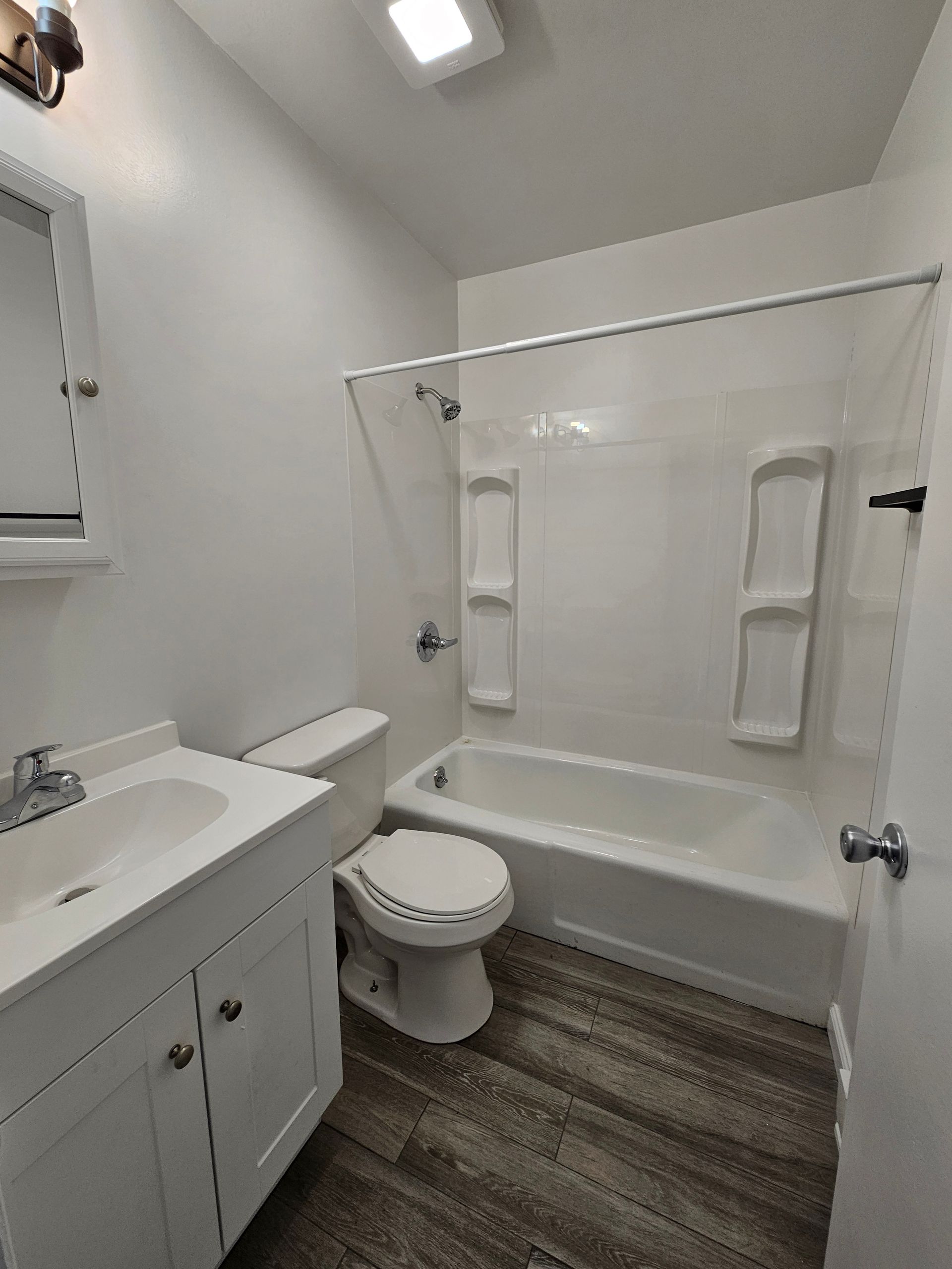 A bathroom with a toilet , sink , bathtub and shower.