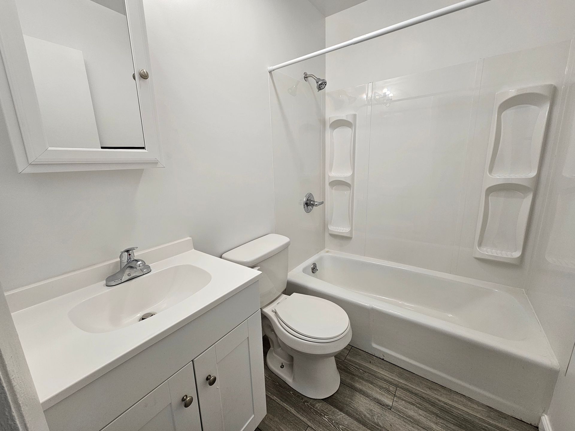 A bathroom with a toilet , sink , and bathtub.
